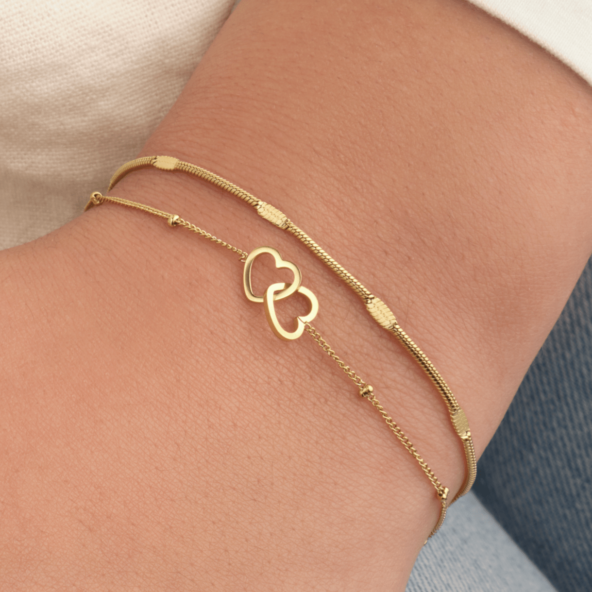 Armband verbonden hartjes goud - Desieradenconcurrent.nl